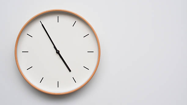 Minimalist wooden Wall Clock on White Wooden Surface with Space for Text  Time Set at 16.55/04.55