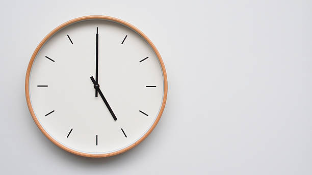 istock Minimalist wooden Wall Clock on White Wooden Surface with Space for Text  Time Set at 17.00/05.00 2166480064