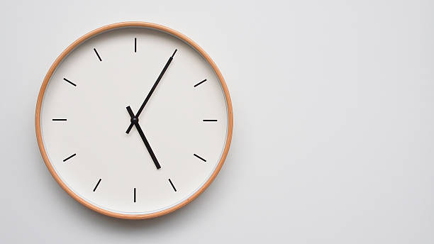 istock Minimalist wooden Wall Clock on White Wooden Surface with Space for Text  Time Set at 17.05/05.05 2166480066