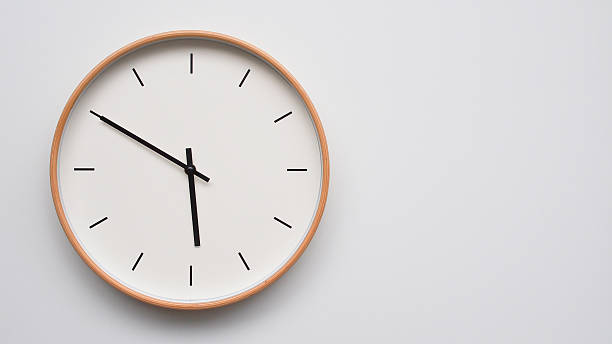 istock Minimalist wooden Wall Clock on White Wooden Surface with Space for Text  Time Set at 17.50/05.50 2166480089