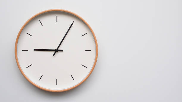 istock Minimalist wooden Wall Clock on White Wooden Surface with Space for Text  Time Set at 9.05 or 21.05 2166480571