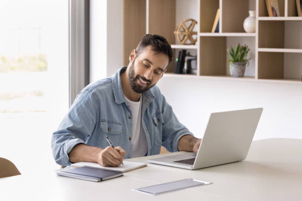 istock Positive Hispanic entrepreneur man using laptop for working in office 2166482521