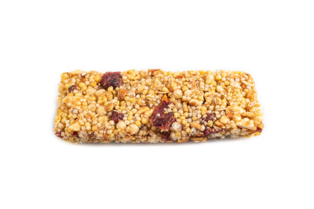 istock Granola bar with, caramel, nuts, flakes isolated on white. Side view, close up. 2166483663