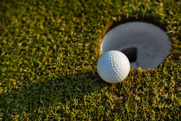 istock Closeup Golf ball on green grass on course 2166484024