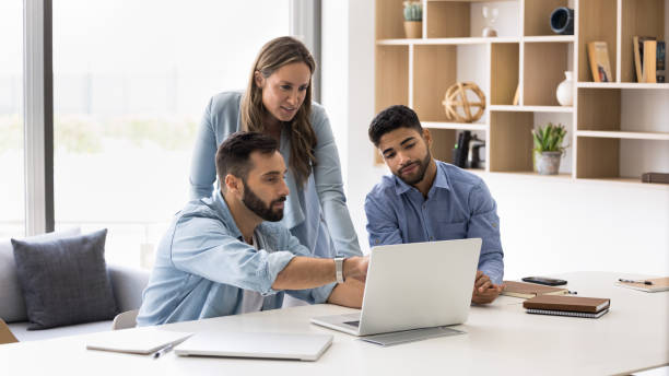 istock Three young multiethnic business colleagues watching website presentation on pc 2166484086