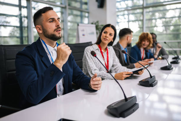 istock Man CEO talking on the microphone on meeting with his colleagues about business plan, future collaboration. 2166484639