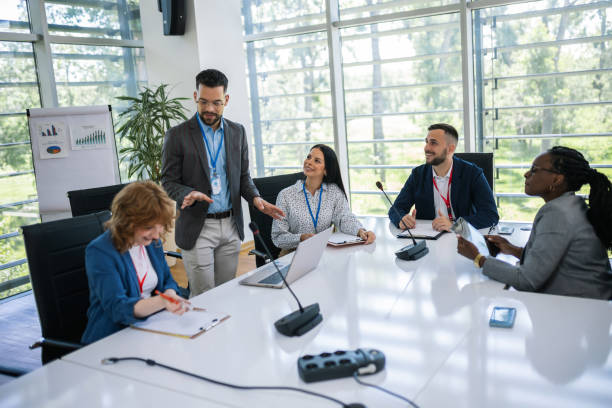 istock Man CEO talking on microphone on a meeting with his colleagues about business plan, future collaboration. 2166485584
