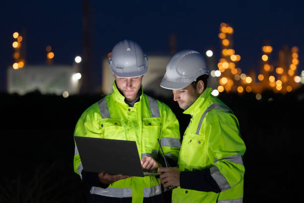 istock Petroleum engineers working at oil refinery site at night 2166485600