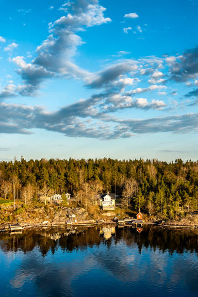 Scenic view of a traditional red cabin with a white bench, overlooking the almö bridge in the beautiful gothenburg archipelago, sweden