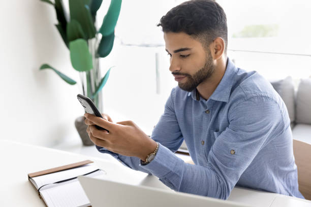 istock Serious young Arab employee man focused on online browsing 2166488080