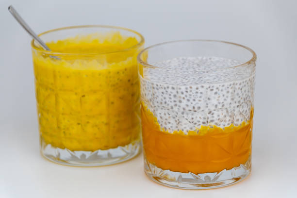 Chia pudding with coconut milk and mango puree in a glass on a white background. Delicious healthy food.