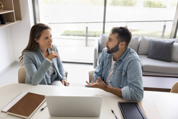 istock Couple of office colleagues discussing work project 2166488978