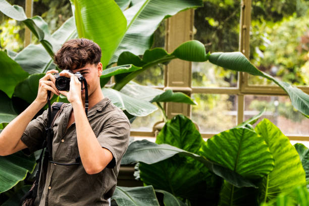 istock young man taking a photo inside the greenhouse 2166488984