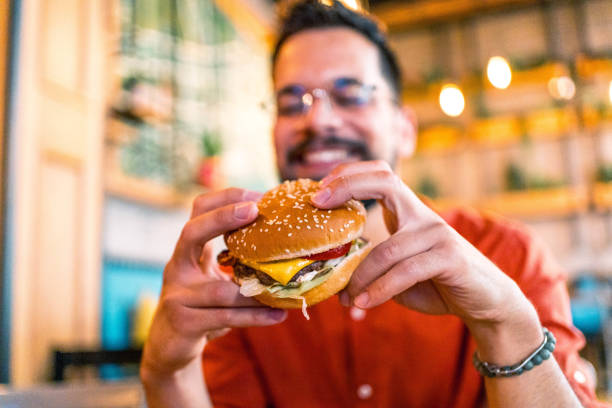 istock Young man enjoying a delicious burger 2166489387