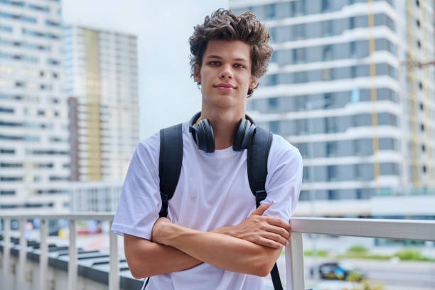 istock Handsome young man looking at camera outdoors, modern skyscrapers urban style background 2166489522
