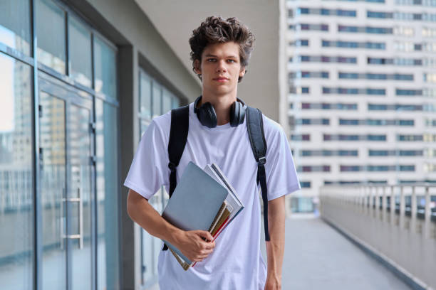 istock Portrait young male college student with backpack textbooks copybooks, outdoor 2166489607