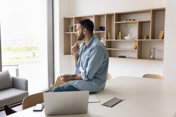 istock Serious thoughtful handsome entrepreneur man in casual sitting at table 2166489724