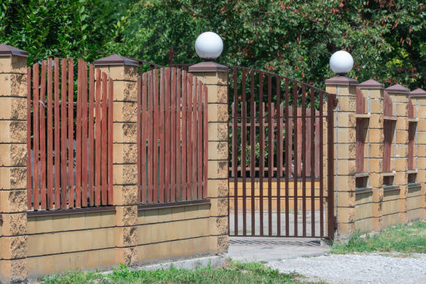 istock Fence with wooden panels and brick wall on yard grounds. 2166492120