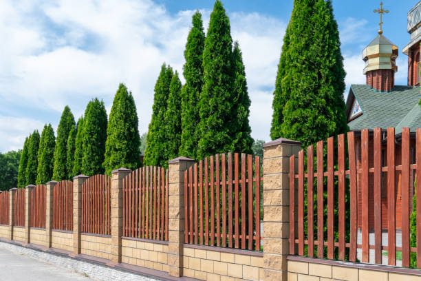 istock Fence with wooden panels and brick wall on yard grounds. 2166492132