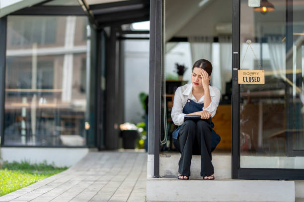 istock A woman sits on a step outside a closed business 2166492381