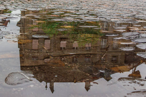 istock An old house reflected in a puddle of water. 2166492879