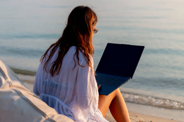 istock A woman working on her laptop on a beautiful beach 2166494112