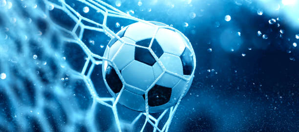istock Soccer ball in goal net on blue background 2166494246