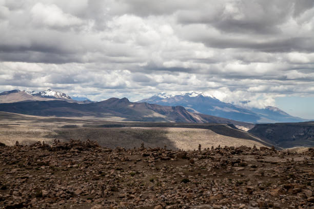 Mountain range on a sunny summer day. White puffy clouds rest on the mountain peaks.