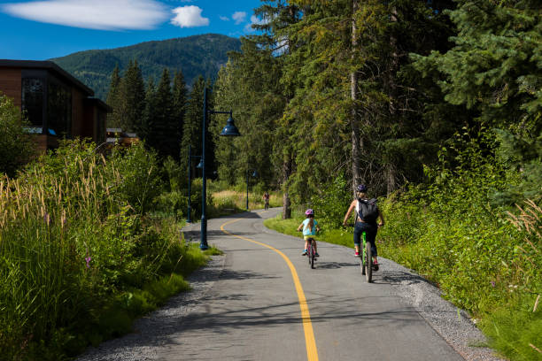 istock Mother and daughter bicycle on paved pathway 2166495216