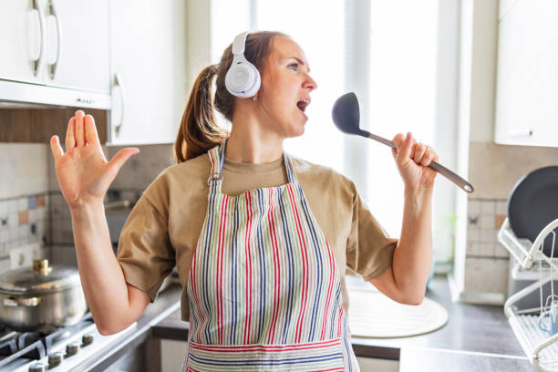 istock Joyful Woman Cooking While Dancing in Kitchen 2166496990