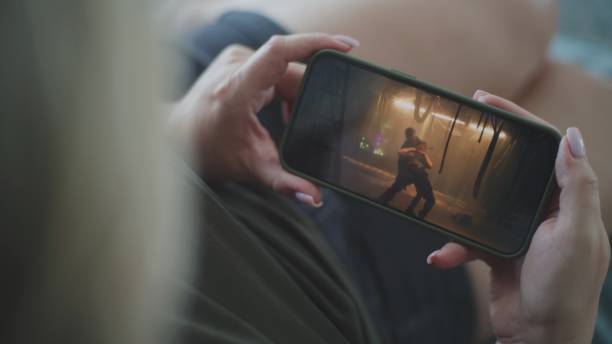 istock Woman watches action movie using smartphone while lying on sofa 2166497347
