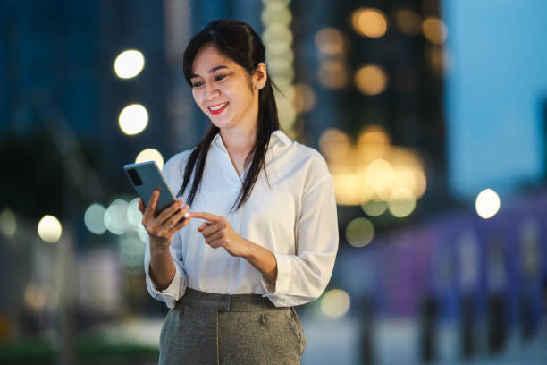 istock Urban Pulse: A Businesswoman's Strategic Path Through the Nighttime Streets 2166500988