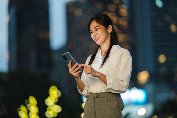 istock Amidst the Neon Glow: A Modern Woman's Digital Journey Through the Urban Night 2166501044