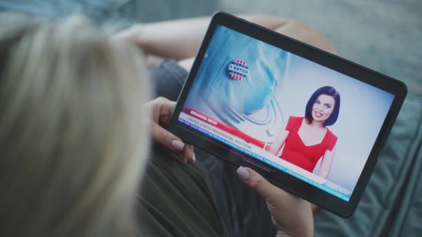 istock Woman watches breaking news about US election using tablet lying on sofa 2166501242