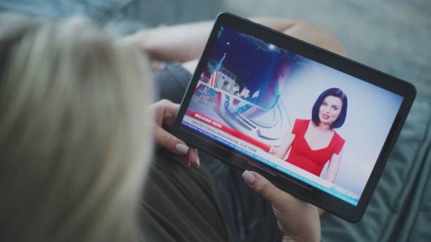 istock Woman watches breaking news about US election using tablet lying on sofa 2166502657