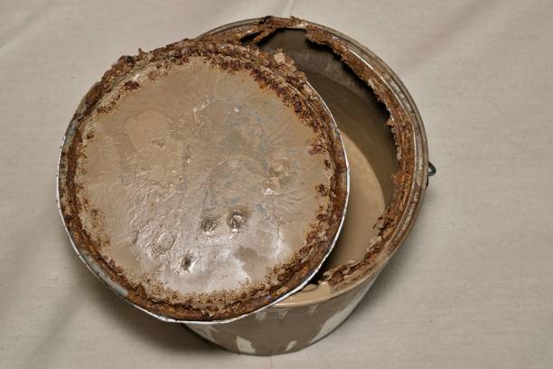 istock Rusted old metal paint tin with open lid on drop cloth brown color. 2166503602