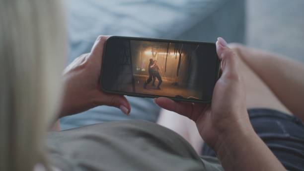 istock Woman watches action movie using smartphone while lying on sofa 2166504547