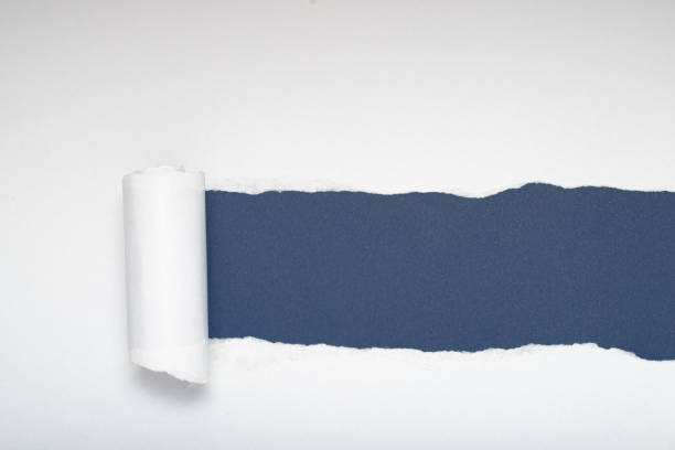 istock Torn white paper revealing a blue-gray background. Space for text. 2166505308