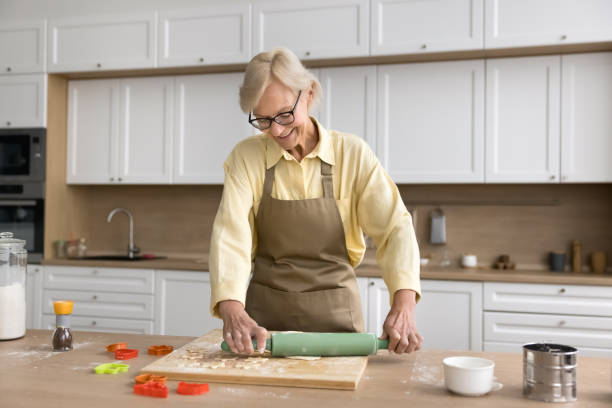 istock Happy blonde senior lady baking biscuits at home, rolling dough 2166508843