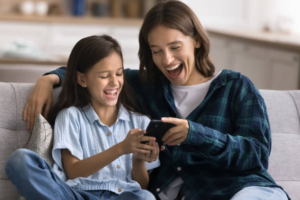 istock Cheerful young mom and happy cute daughter kid using application 2166509390