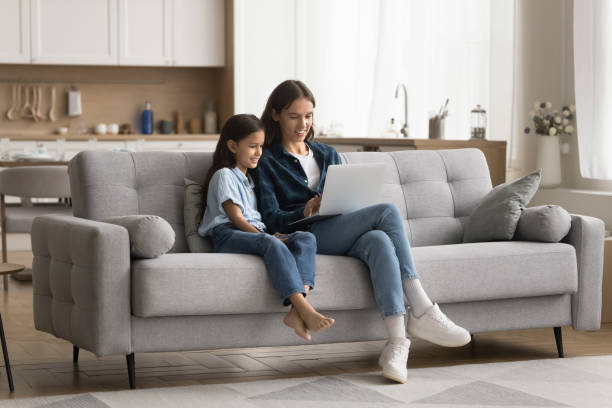 istock Cute daughter girl and young mom using laptop computer 2166510412