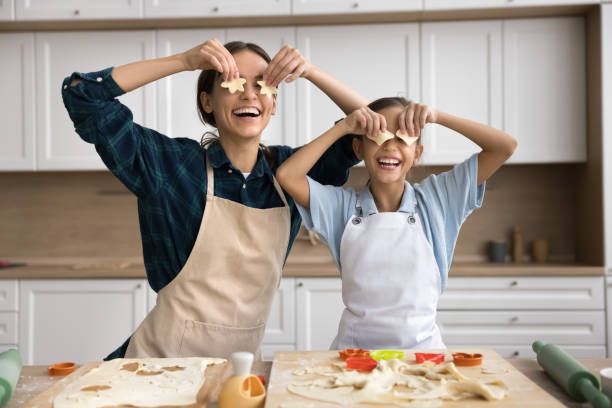 istock Joyful young baker mother and daughter child baking cookies 2166512211