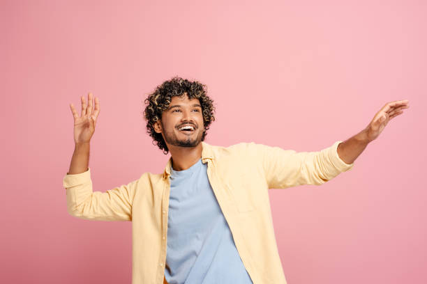 istock Cheerful young Indian man is dancing and having fun on pink background 2166513382