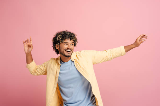 istock Cheerful Indian young man dancing and having fun on pink background 2166513403