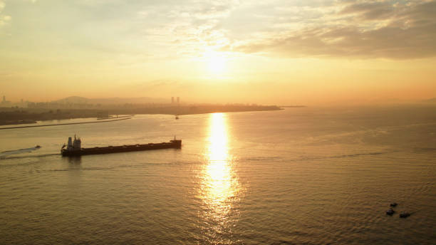 Sun rises above sea, Aerial view of cargo ship, Bosphorus Strait