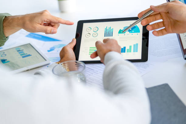 istock Three  business men meeting and looking at financial data, charts and graphs on a digital tablet 2166518873