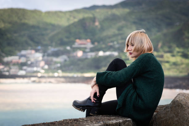 In an abandoned house near by sea and mountain Generation Z non-binary person exhibiting mental problems. transgender, 20-29 years old, self healing