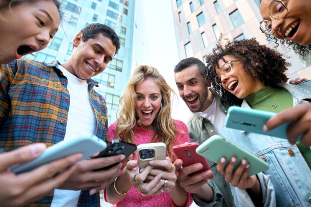 istock Group of young mixed race people with mobile phones. Excited students using technological devices 2166521733