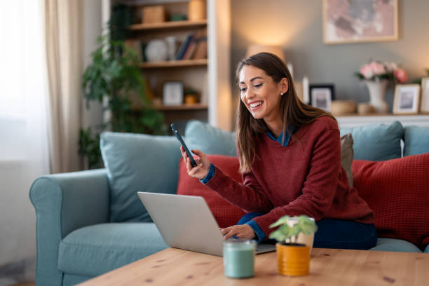 istock Caucasian Woman Multitasking with Technology on Sofa 2166523542