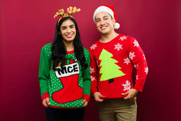istock Cute young couple wearing funny and ugly christmas sweaters smiling while posing on a red background 2166526932